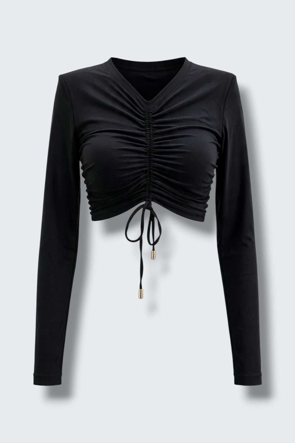 The Saint 54 black long-sleeve crop top with adjustable front ruching, shoulder pads, and gold-tone tie tips.