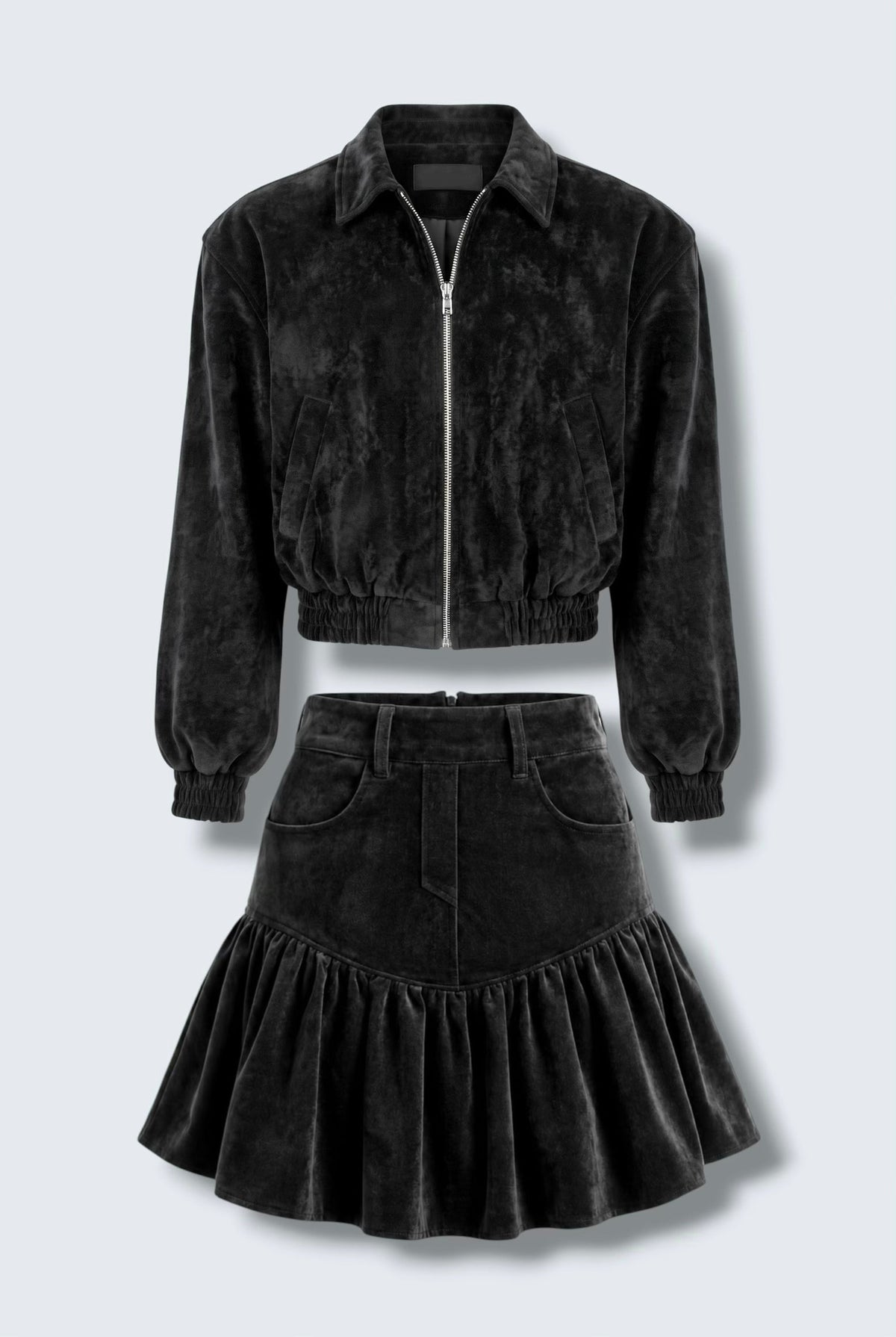 The Saint 54 black suede bomber jacket and ruffled mini skirt set worn by a model against a white background.
