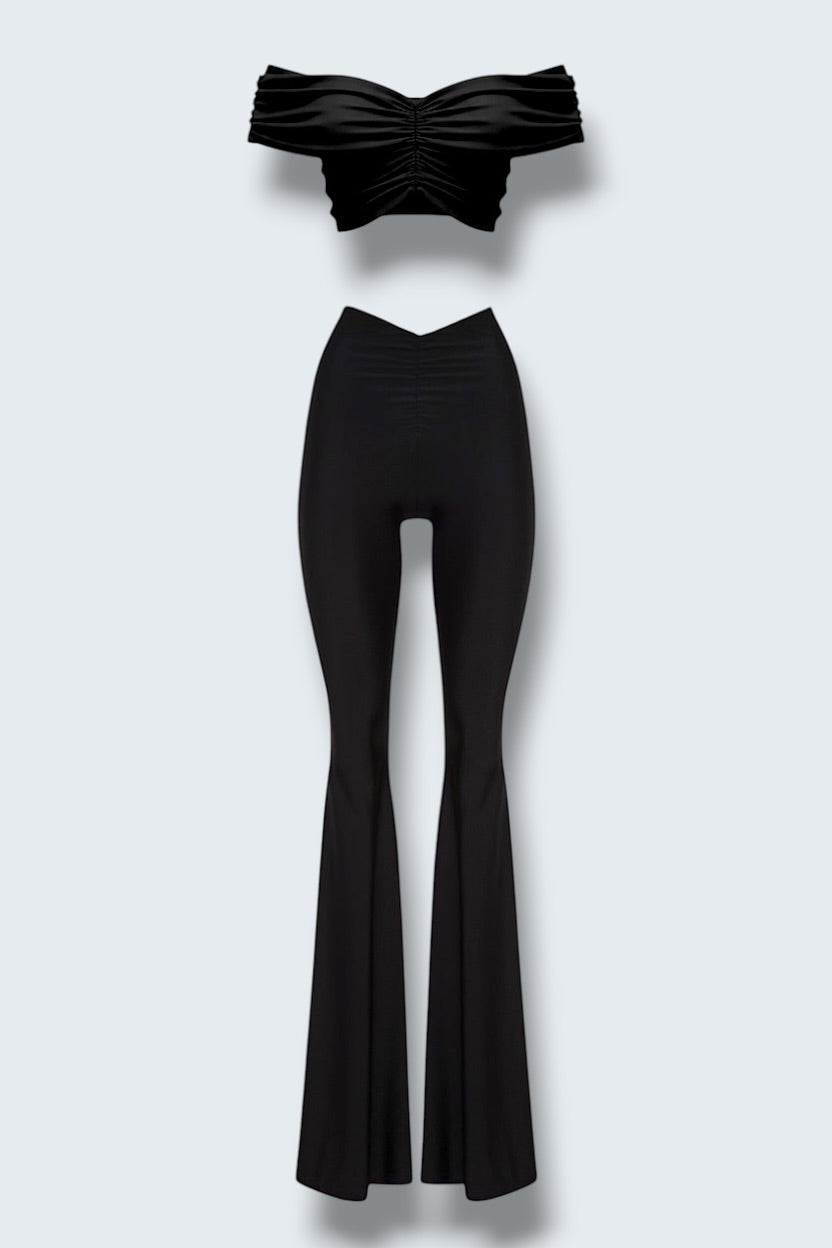 The Saint 54 black two-piece set with a cropped off-shoulder top and flared trousers featuring gathered details.