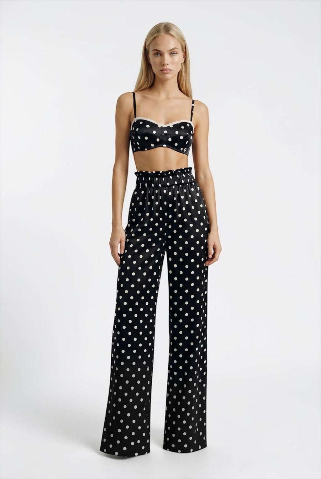 The Saint 54 black and white polka dot crop top with delicate ecru lace trim and adjustable straps on a model.